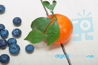 Tangerine And Blueberry On White Table Stock Photo