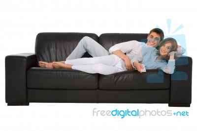 Teenage Couple Lying On Sofa Stock Photo