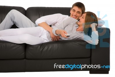 Teenage Couple Lying On Sofa Stock Photo