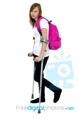 Teenager Student Holding Crutches And Walking Stock Photo