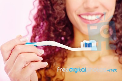 Teeth Brush And Girl's Smile Behind Stock Photo