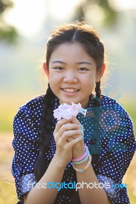 Thai 12s Years Girl Sitting On Garden Field With Pink Flowers In Hand Toothy Smiling Face Happiness Emotion Stock Photo