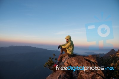 Thai Woman Sitting On Cliff Rock Enjoy Mountains View Stock Photo