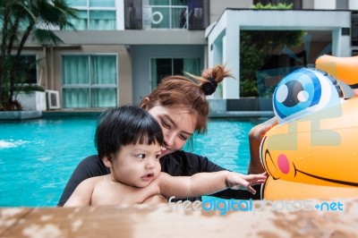 The Kid And Mom Play Together In The Pool Stock Photo The Kid And Mom Play Together In The Pool Stock Photo