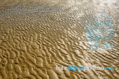 The Texture Of Wet Sea Sand With Patterns Of Water Stock Photo