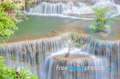 The Water Flowing Over Rocks And Trees Down A Waterfall At Huay Mae Khamin Waterfall National Park ,kanchana Buri In Thailand Stock Photo