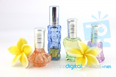 The Yellow Flowers And Orange,blue,green,violet Perfume Bottles Stock Photo