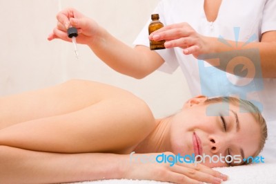 Therapist Putting Essential Oil Woman's Back Stock Photo