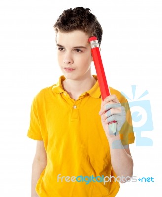 Thoughtful Boy Holding Pencil Stock Photo