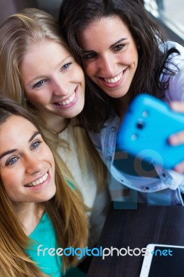 Three Friends Taking Photos With A Smartphone Stock Photo