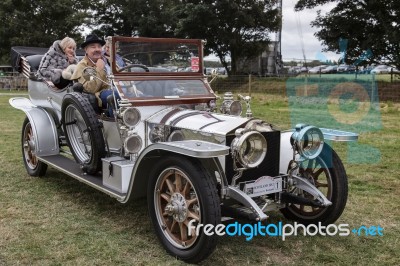 Three People Sitting In A Vintage Silver Rolls Royce Stock Photo
