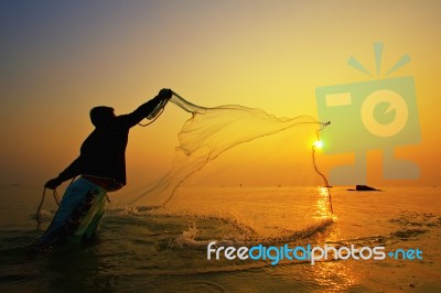 Throwing Fishing Net During Sunset Stock Photo
