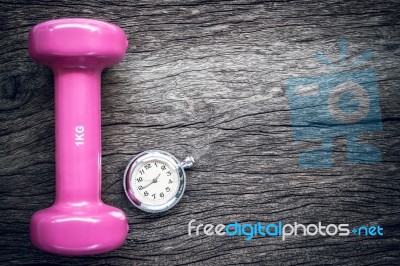 Time For Exercising Pocket Watch And Dumbbell On Wooden Background Stock Photo