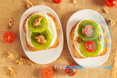 Toast With Kiwi, Cheese, Walnuts And Cherry Tomato Stock Photo