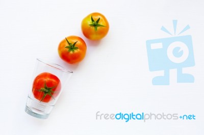 Tomatoes With Glass On A White Stock Photo