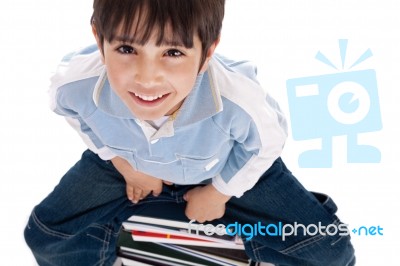 Top Angle Image Of Kid Sitting On Books Stock Photo