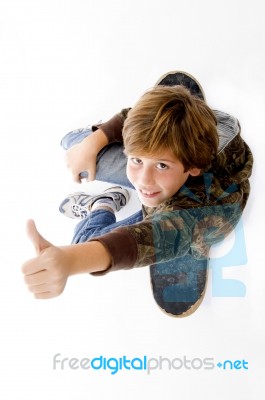 Top View Of Boy Sitting On Skateboard Stock Photo