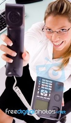 Top View Of Smiling Employee Showing Phone Receiver Stock Photo