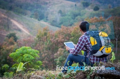 Tourists Look At A Map On The Tablet On Mountain Stock Photo