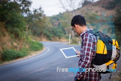 Tourists Man Look At A Map On The Tablet On Mountain Roads Stock Photo