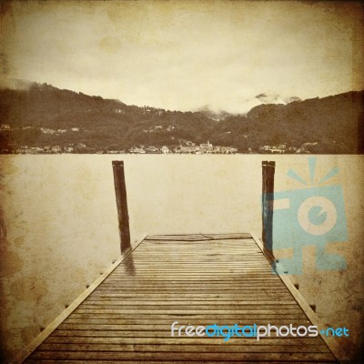 Tranquil Scene Of Old Wooden Pier And Misty Italian Alps Mountai… Stock Photo