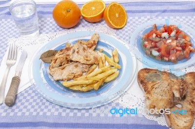 Turkey Steak With French Fries And Tomato Salad Stock Photo
