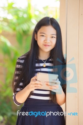 Twelve Years Old Asian Kid Standing With Happiness Smiling Face And Tablet Computer In Hand Use For Modern Life Of Education And Livestyle Stock Photo