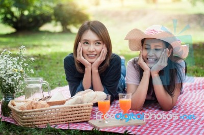 Two Asian Girlfriends Lying On The Lawn, Women In Park During Th… Stock Photo