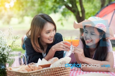 Two Asian Girlfriends Lying On The Lawn, Women In Park During Th… Stock Photo