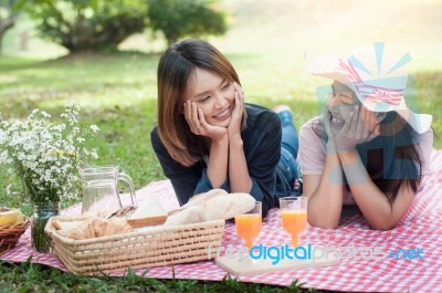 Two Asian Girlfriends Lying On The Lawn, Women In Park During Th… Stock Photo