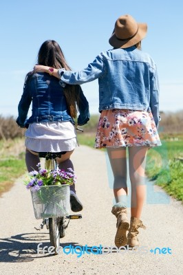 Two Beautiful Young Women With A Vintage Bike In The Field Stock Photo