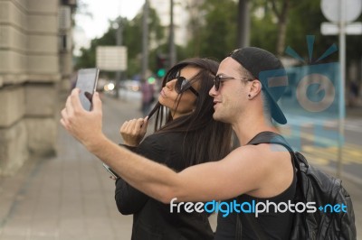 Two Cheerful Friends Taking Photos Of Themselves On Smart Phone Stock Photo
