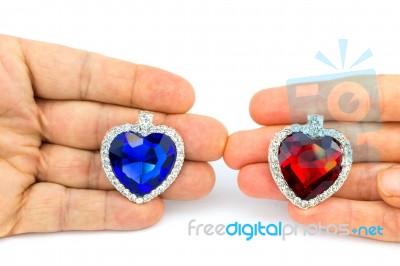 Two Jewelry Hearts On Hand Of Man And Woman Stock Photo