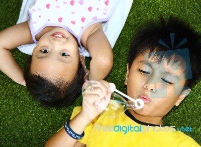 Two Kids Lying And Playing Stock Photo