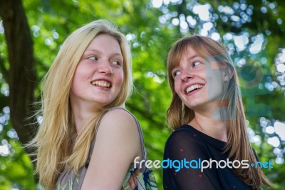 Two Long-haired Girls Laughing To Each Other Stock Photo