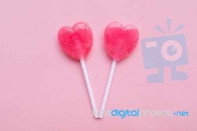 Two Pink Valentine's Day Heart Shape Lollipop Candy On Empty Pastel Pink Paper Background. Love Concept. Top View. Minimalism Colorful Hipster Style Stock Photo