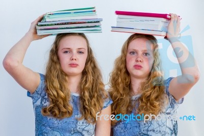 Two Schoolgirls With Textbooks On Their Head Stock Photo