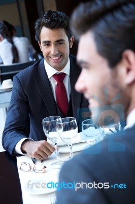 Two Smiling Business Men Have Dinner At Restaurant Stock Photo