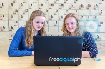 Two Teenage Girls Looking At Computer In Chemistry Lesson Stock Photo