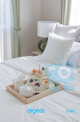 Twooden Ray Of Tea Set And Cup Cake On White Bed I Stock Photo