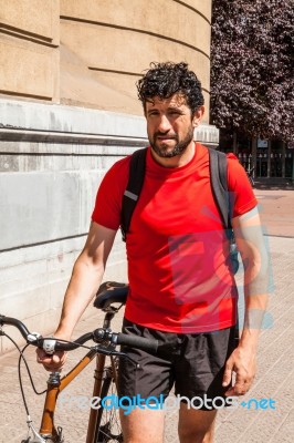 Urban Athlete Walking His Bike Through A City Stock Photo