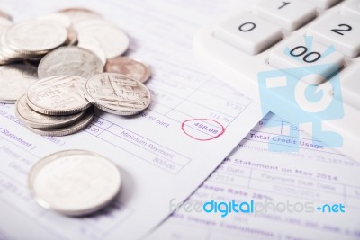 Utility Bill With Silver Coins And Calculator Stock Photo