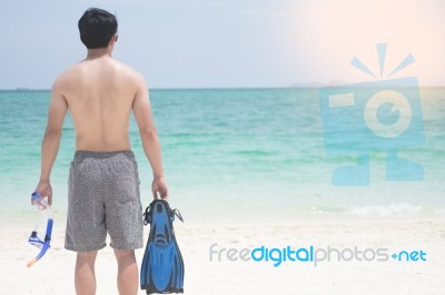Vacation Backside Of Man Holding Snorkeling Gear On Tropical On Stock Photo