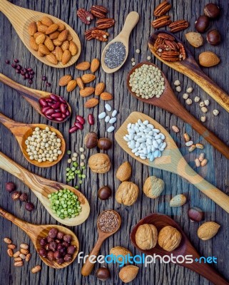 Various Legumes And Different Kinds Of Nutshells In Spoons. Waln… Stock Photo