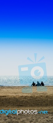 Vertical Three Freinds Sitting On The Ocean Beach Background Bac… Stock Photo