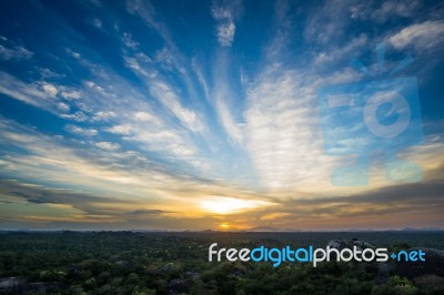 Vibrant Sunset Over Jungle Landscape With Boulders And Trees Stock Photo