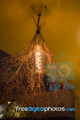 Vintage Hanging Light Bulb Over Gray Room Stock Photo