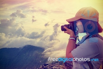 Vintage Style Hiker Taking Photo At Sunset Stock Photo