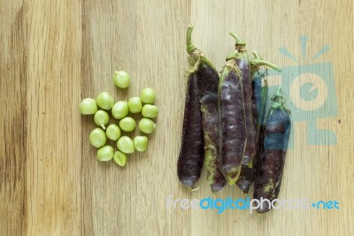 Violet Peas On A Wooden Desk Stock Photo