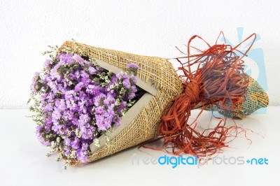 Violet Statice Flower Bouquet On White Cement Wall And White Table Stock Photo